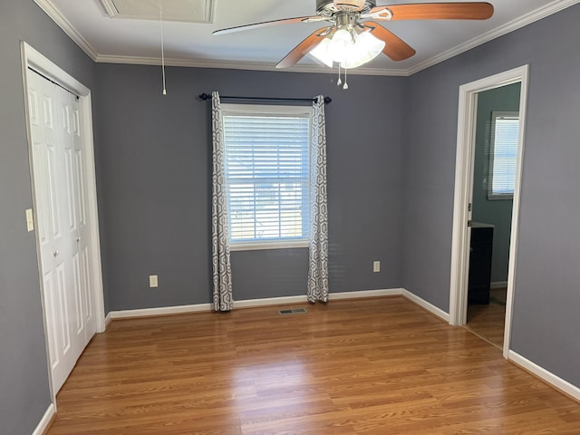 spare room featuring attic access, crown molding, visible vents, and wood finished floors