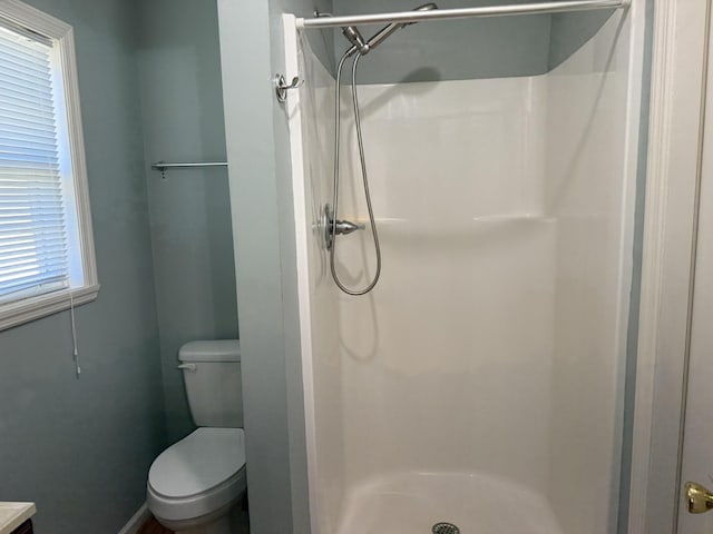 full bath featuring a stall shower and toilet