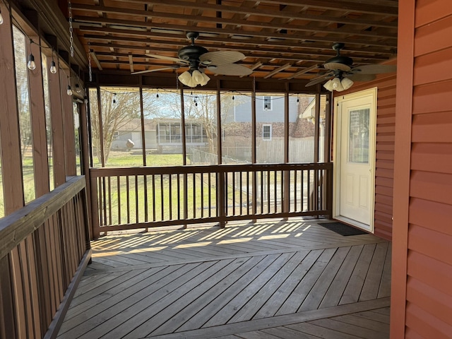 unfurnished sunroom with ceiling fan