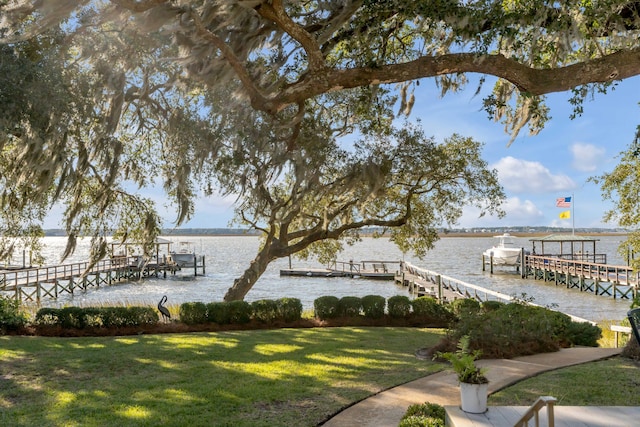 dock area with a water view and a lawn