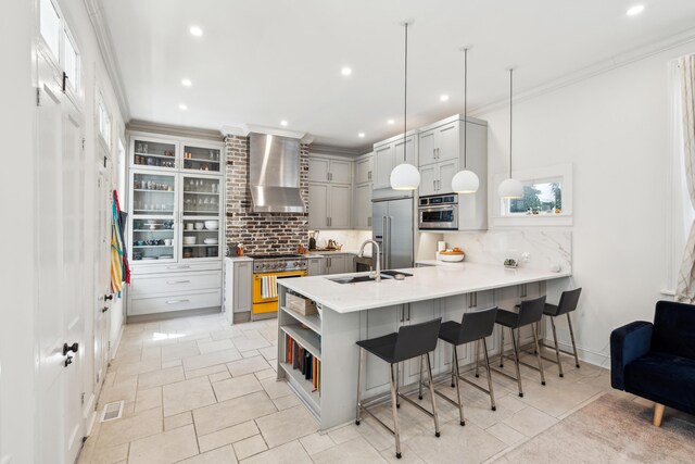 11 Franklin St, Charleston, SC 29401 - kitchen with wall chimney range hood, high end appliances, a peninsula, tasteful backsplash, and recessed lighting
