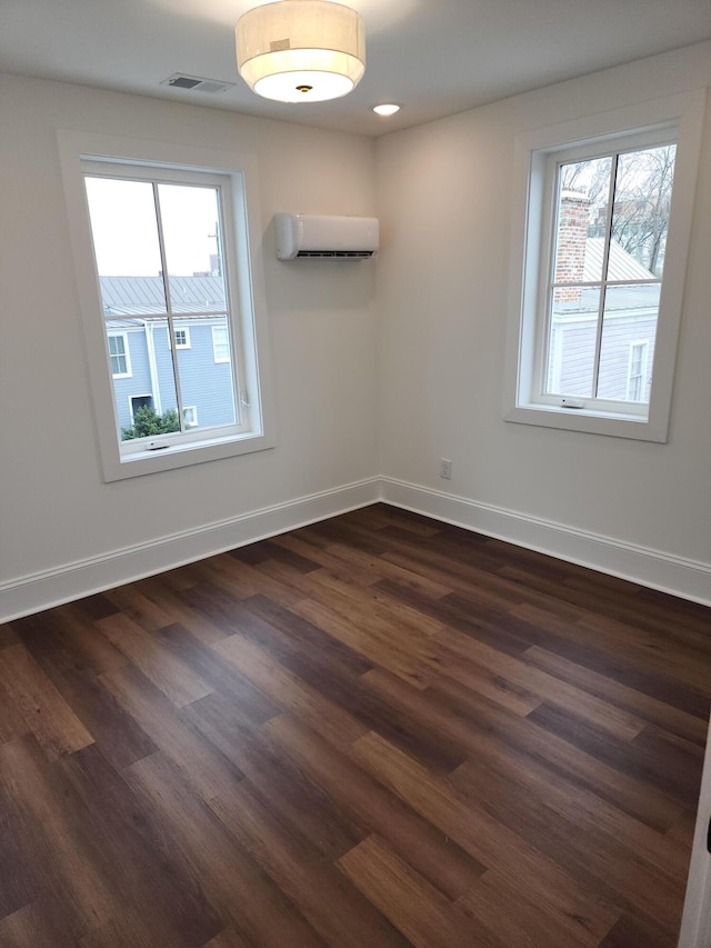 unfurnished room featuring an AC wall unit and dark wood-type flooring