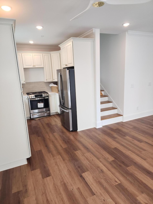 kitchen with white cabinetry, ornamental molding, stainless steel appliances, and dark hardwood / wood-style floors