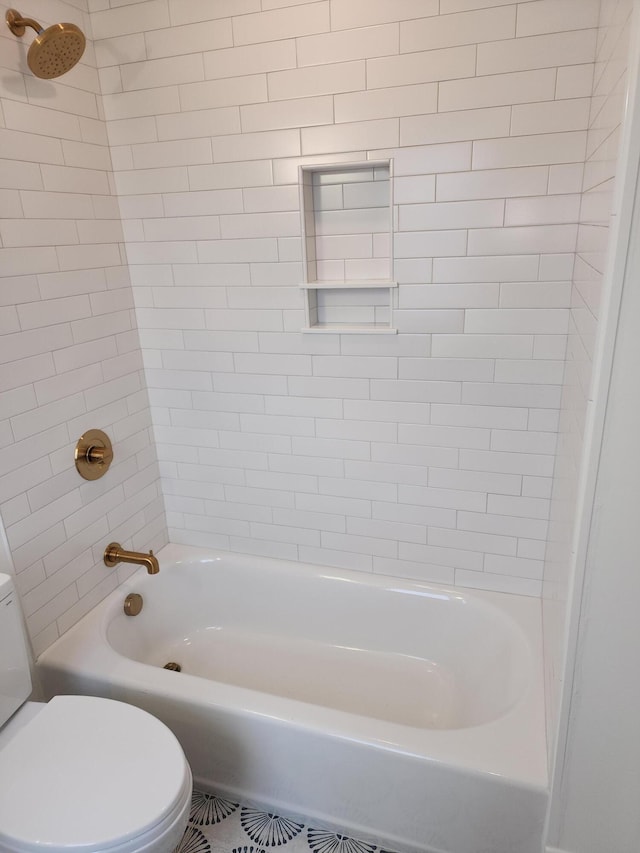 bathroom with toilet and tiled shower / bath combo