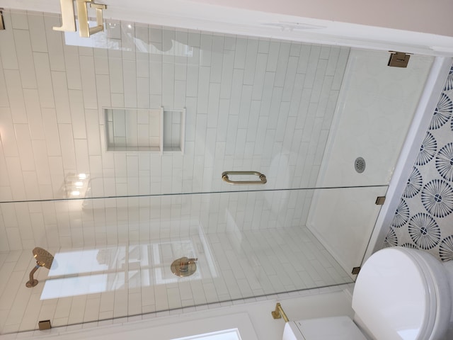 bathroom featuring a tile shower and toilet