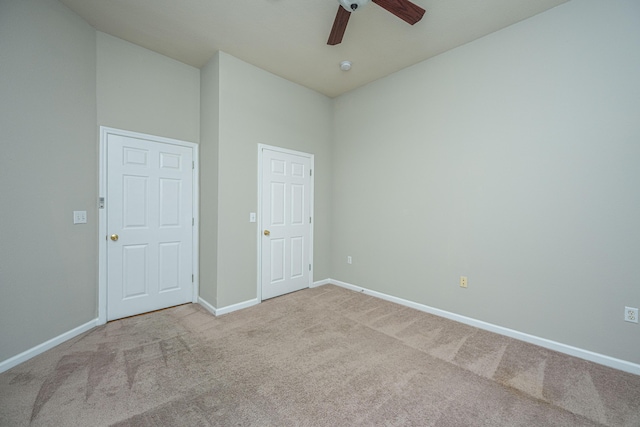 spare room featuring ceiling fan and light carpet