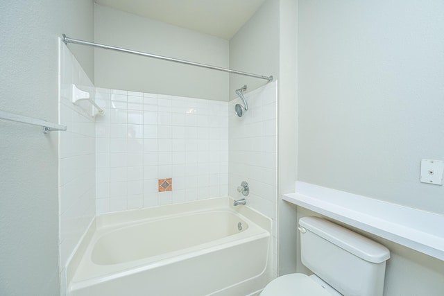 bathroom featuring tiled shower / bath combo and toilet