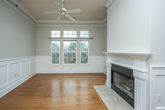 unfurnished living room with ceiling fan, light wood-type flooring, and ornamental molding