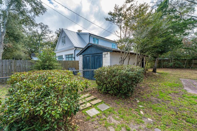 view of side of home featuring metal roof, concrete block siding, and a fenced backyard