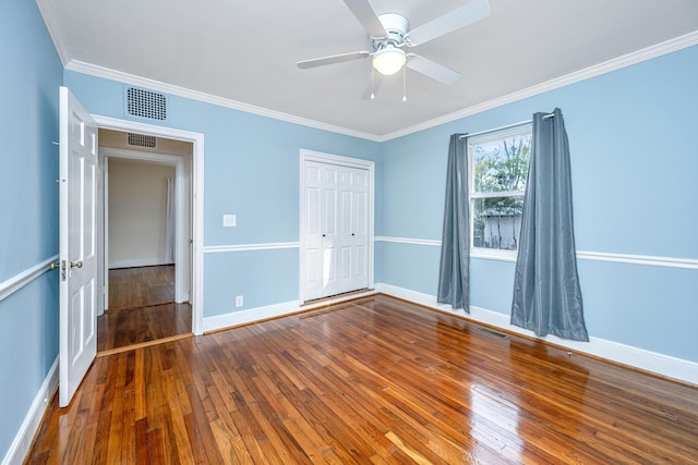 unfurnished bedroom featuring hardwood / wood-style floors, visible vents, and crown molding