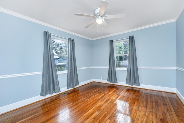 spare room featuring ornamental molding, hardwood / wood-style floors, visible vents, and baseboards