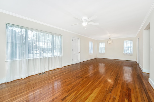 unfurnished living room featuring baseboards, crown molding, visible vents, and hardwood / wood-style floors