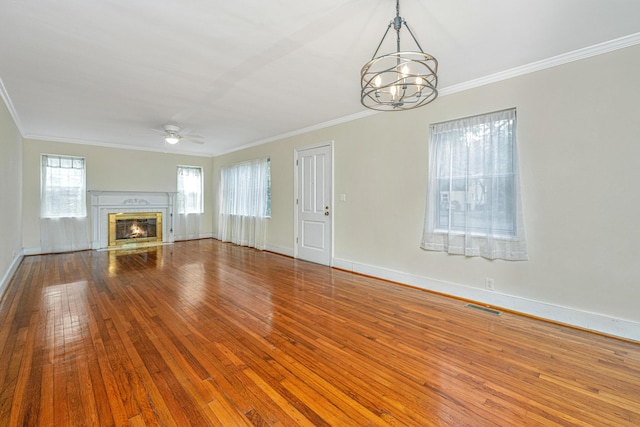 unfurnished living room featuring visible vents, baseboards, a glass covered fireplace, wood-type flooring, and crown molding