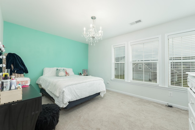 bedroom with light carpet and a notable chandelier