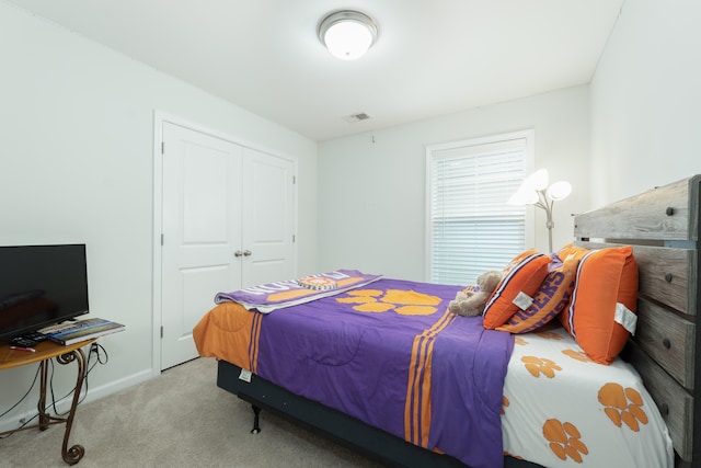 bedroom with light colored carpet and a closet