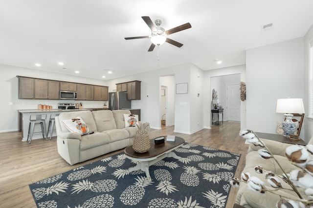 living room with ceiling fan and light wood-type flooring