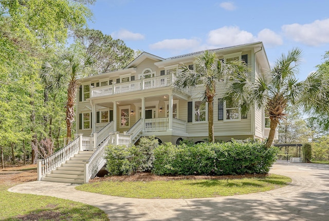 beach home with a porch, a balcony, and stairs