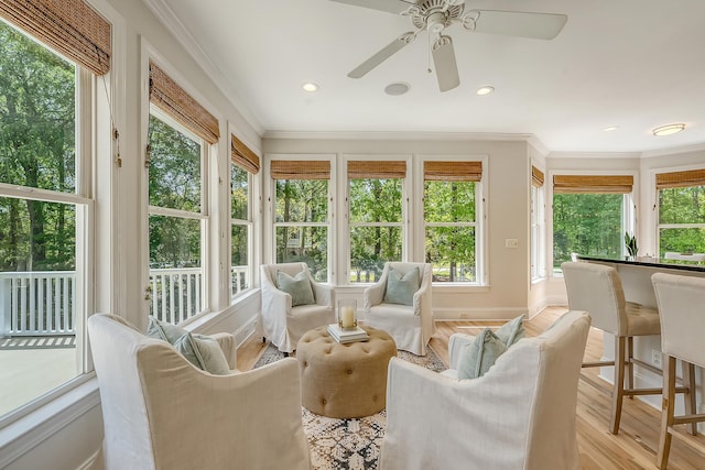 sunroom / solarium with ornamental molding, recessed lighting, plenty of natural light, and wood finished floors