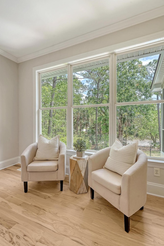 sitting room with light wood-type flooring, baseboards, and ornamental molding