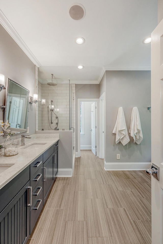 full bath with a sink, ornamental molding, baseboards, and a stall shower