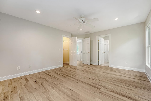 unfurnished bedroom with multiple windows, baseboards, light wood finished floors, and recessed lighting