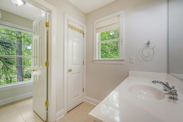 bathroom with tile patterned floors, baseboards, and a sink