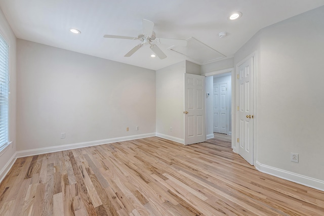 interior space with light wood-style flooring, attic access, baseboards, and recessed lighting