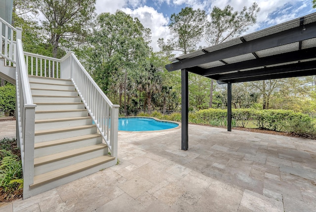 outdoor pool with a patio area and stairs