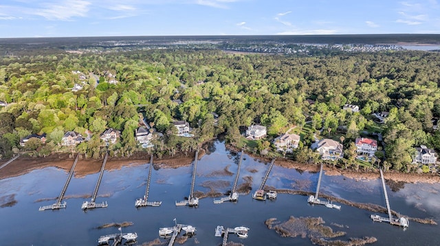 drone / aerial view featuring a wooded view and a water view