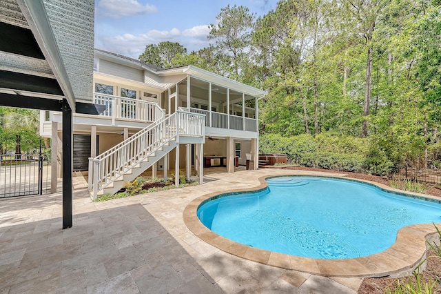 outdoor pool featuring a patio area, stairway, and a sunroom