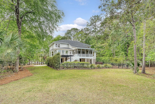 rear view of property with a yard, fence, a sunroom, and stairs