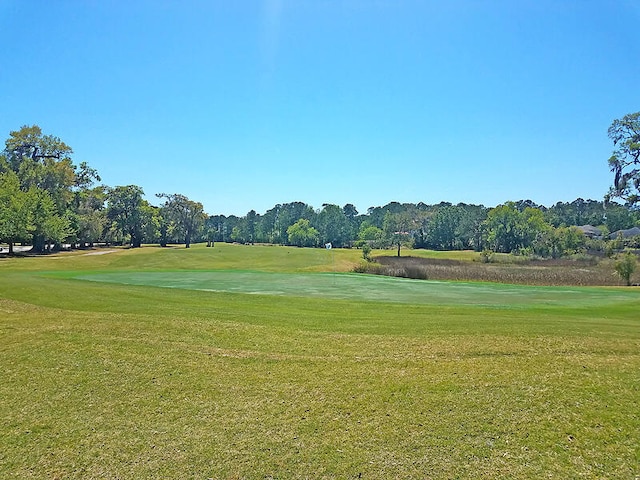 view of home's community featuring a yard and view of golf course