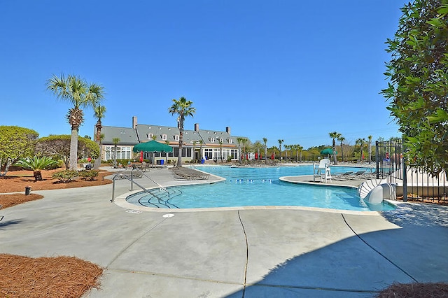 pool with a patio area and fence