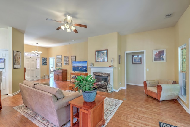 405 Decatur Dr, Summerville, SC 29486 - living area featuring a fireplace, light wood-style floors, ceiling fan with notable chandelier, baseboards, and visible vents