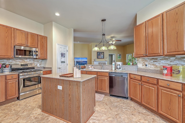 405 Decatur Dr, Summerville, SC 29486 - kitchen with a peninsula, a kitchen island, light stone countertops, a sink, and stainless steel appliances