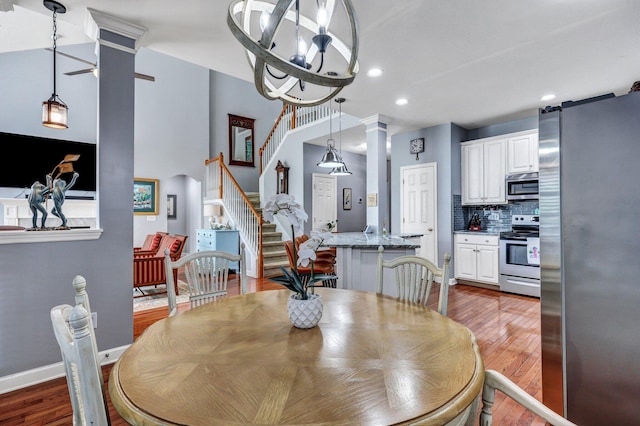 dining space with decorative columns, recessed lighting, stairway, baseboards, and hardwood / wood-style flooring