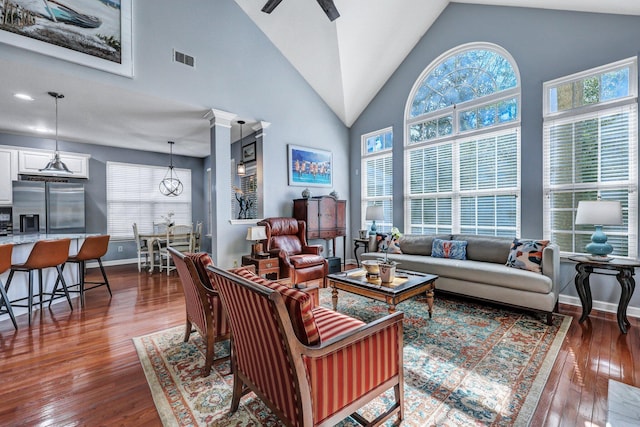 living area with dark wood-style floors, plenty of natural light, and high vaulted ceiling