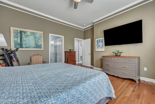 bedroom featuring baseboards, ceiling fan, ensuite bathroom, crown molding, and light wood-style floors