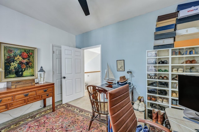 carpeted home office featuring ceiling fan