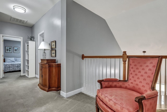 sitting room featuring carpet floors, baseboards, visible vents, and vaulted ceiling