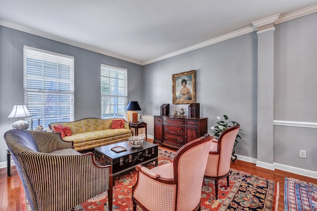 living room featuring ornate columns, baseboards, wood finished floors, and ornamental molding