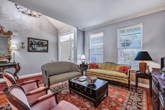 living room featuring crown molding, baseboards, and wood finished floors