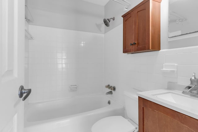 bathroom featuring tile walls, toilet, bathtub / shower combination, and vanity
