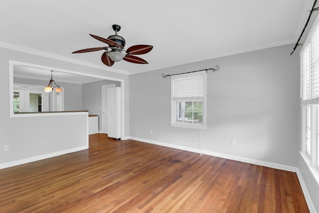 unfurnished room with hardwood / wood-style floors, crown molding, a ceiling fan, and baseboards