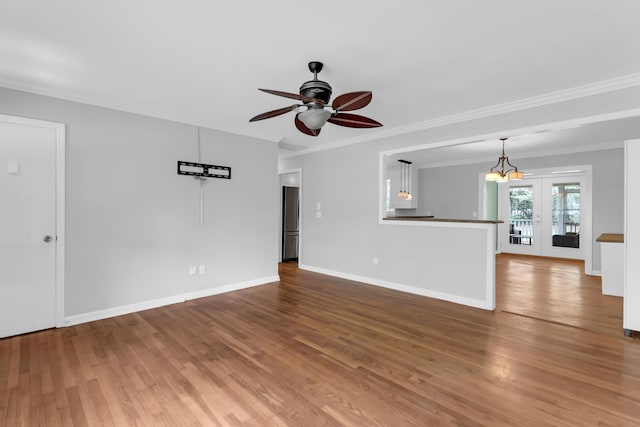 unfurnished living room featuring crown molding, baseboards, a ceiling fan, and wood finished floors