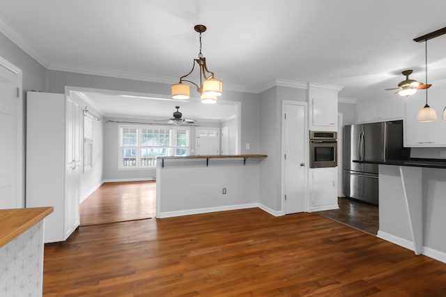 kitchen with white cabinetry, appliances with stainless steel finishes, a ceiling fan, and crown molding