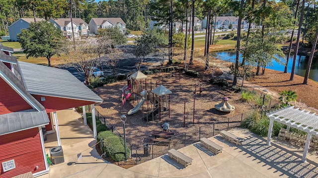 view of yard featuring a playground, a water view, and a pergola