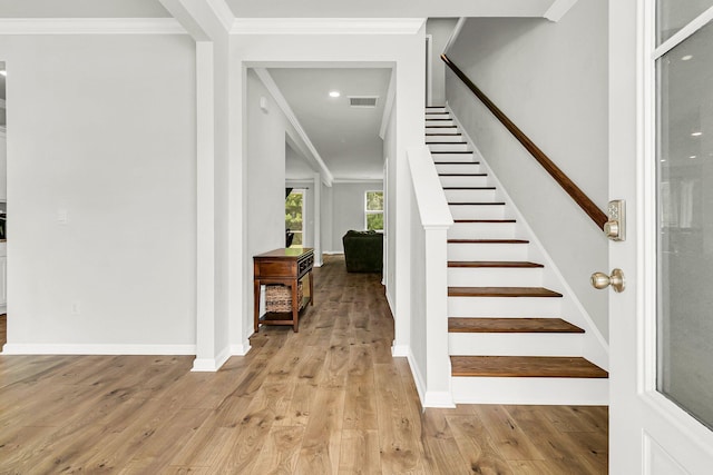 foyer entrance featuring light hardwood / wood-style flooring and ornamental molding