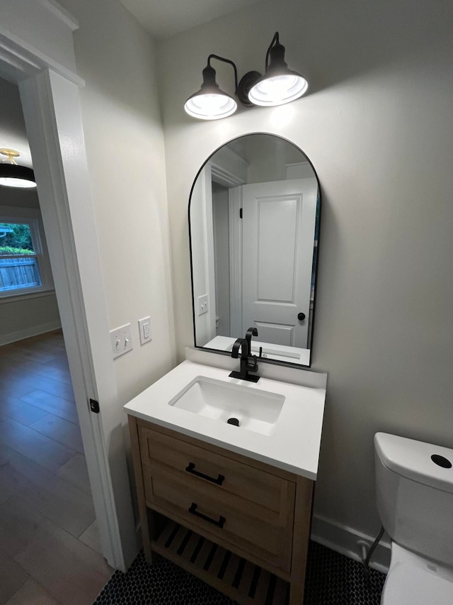 bathroom with wood-type flooring, toilet, and vanity