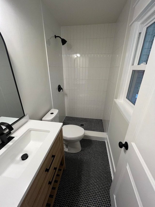 bathroom featuring tiled shower, vanity, toilet, and tile patterned floors